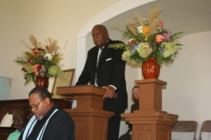 Former Director Stanton stands at the podium in the chapel.
