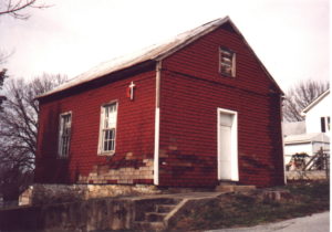Viewer is facing the chapel, which is painted red.